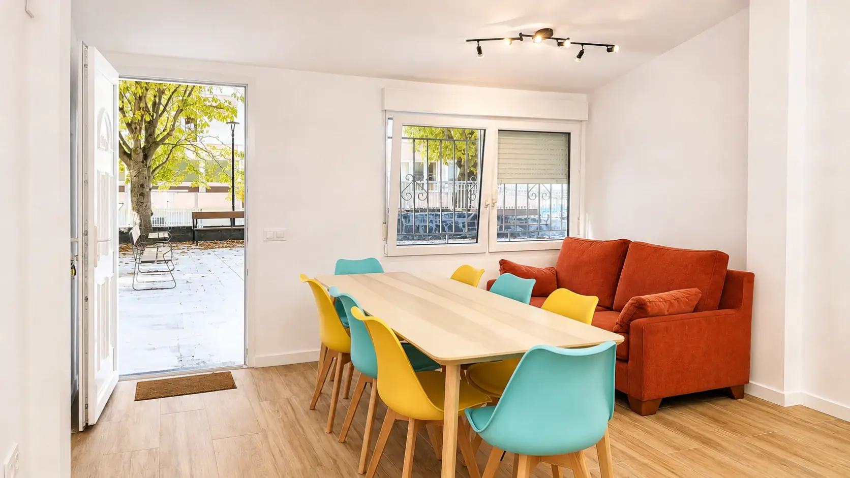 Salón comedor privado de Punto de Encontro con mesa, sillas, sofá y acceso al exterior en A Coruña.